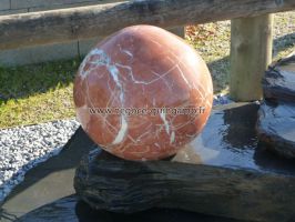 Sphère de marbre rouge poli.
